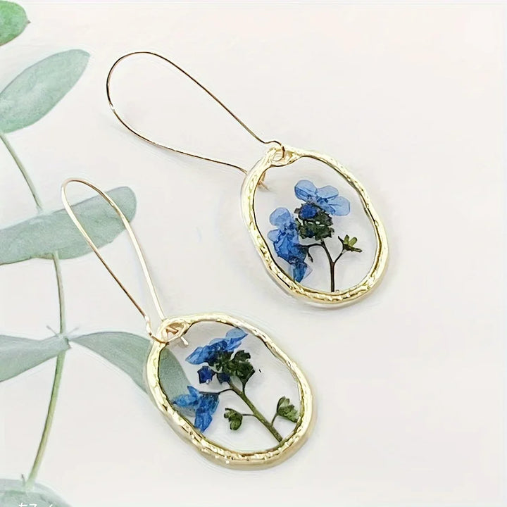Brincos vibrantes de flor miosótis