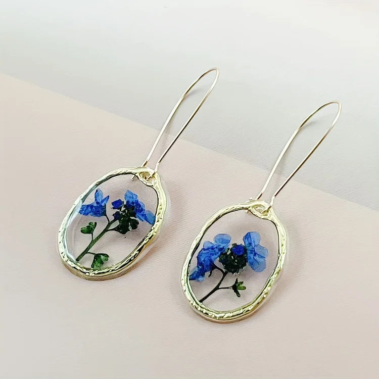 Brincos vibrantes de flor miosótis