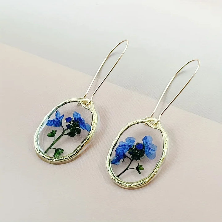 Brincos vibrantes de flor miosótis