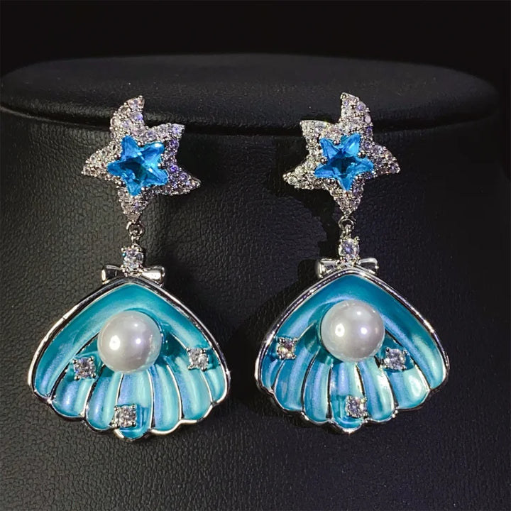 Brincos de conchas cravejadas de diamantes e pérolas