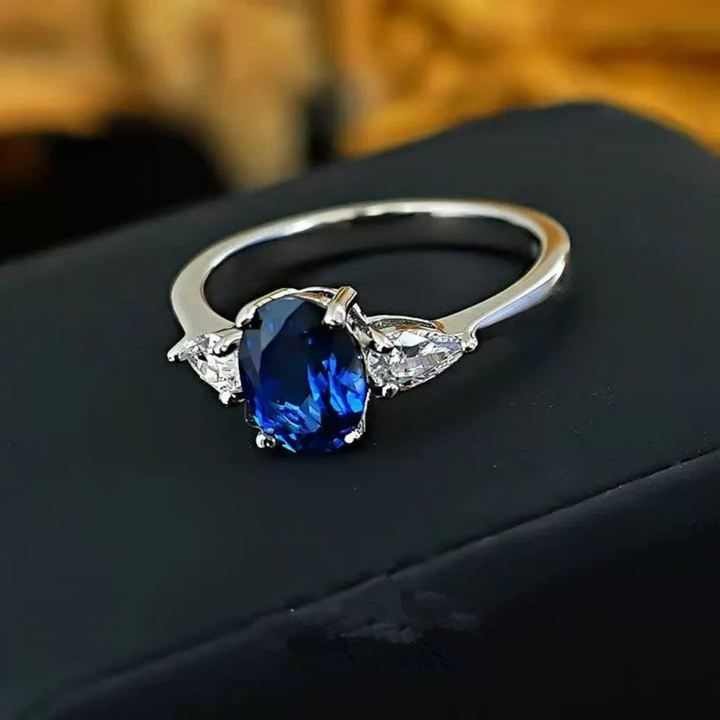 Anel Dourado Marin Thorneau com Pedra Azul e Laterais de Cristais