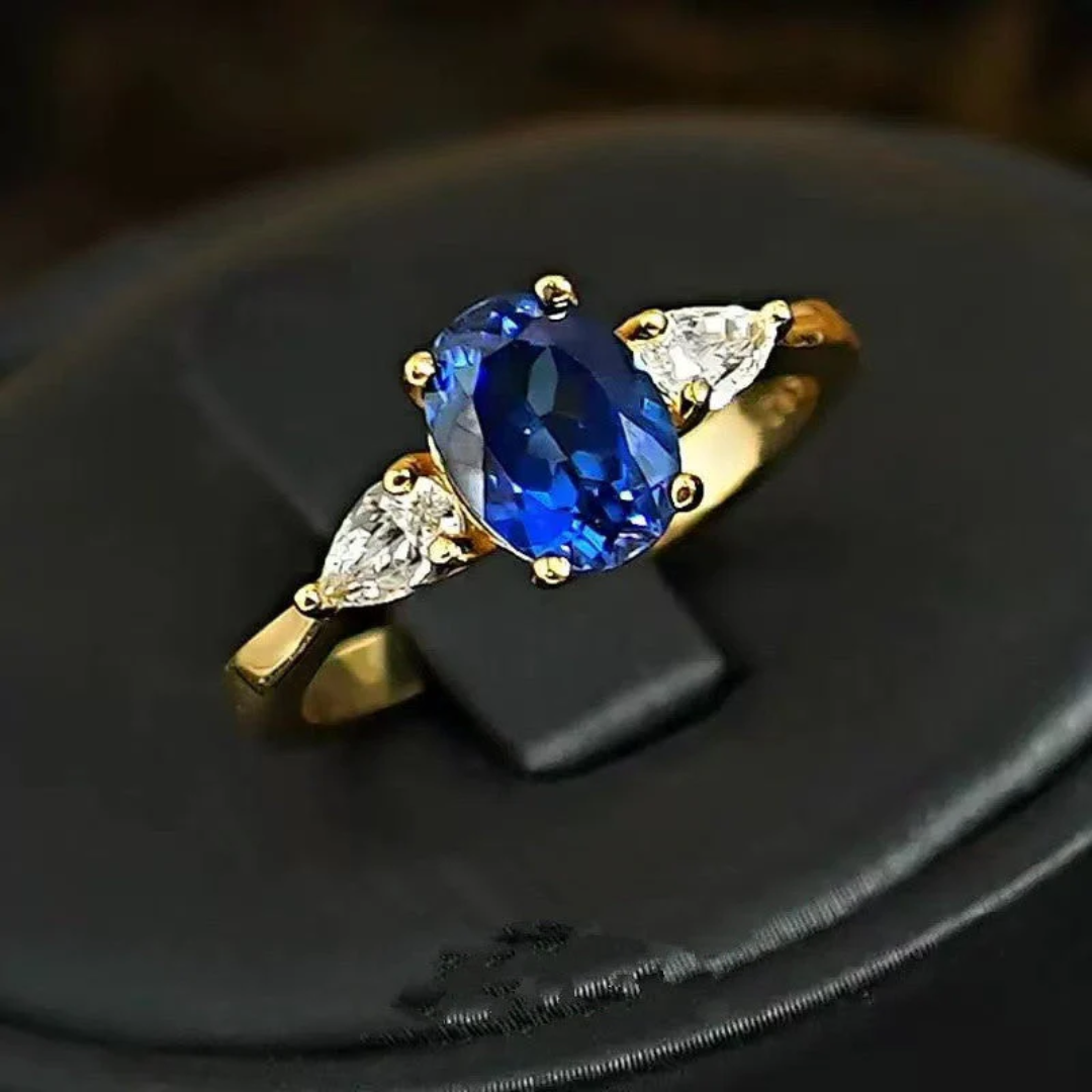 Anel Dourado Marin Thorneau com Pedra Azul e Laterais de Cristais