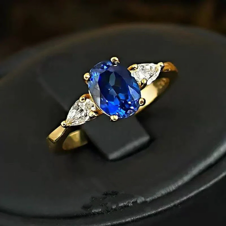 Anel Dourado Marin Thorneau com Pedra Azul e Laterais de Cristais